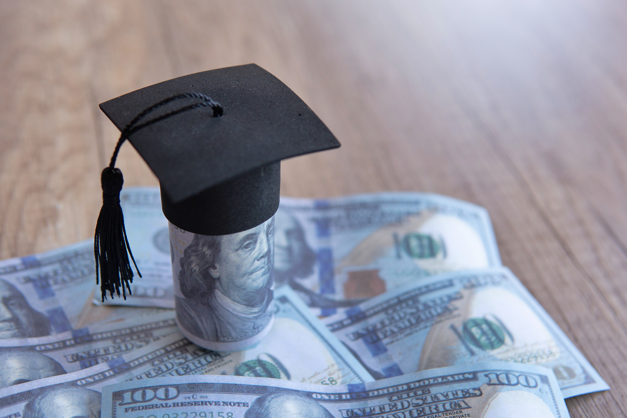 Closeup image of graduation cap and money on table. Scholarship, educational fees concept. Copy space for text.